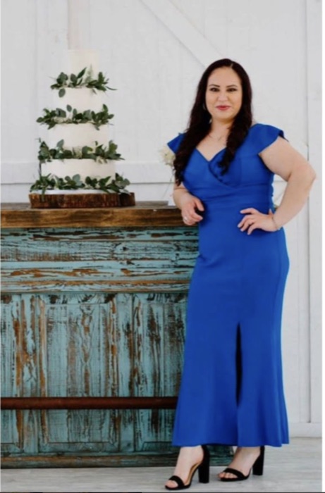 Ana standing beside one of her elegant tiered wedding cakes today